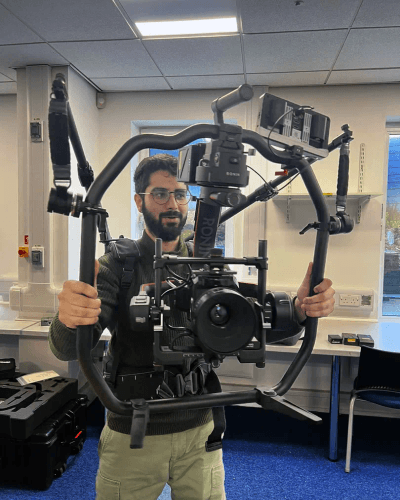 Cinematographer operating professional camera rig indoors.